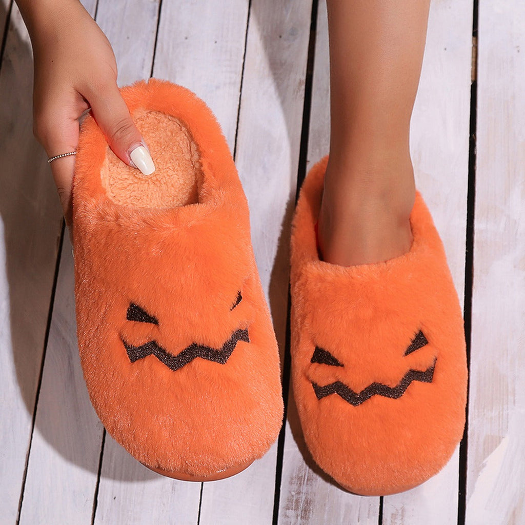 Woman wearing orange pumpkin plush slippers in a cozy autumn living room